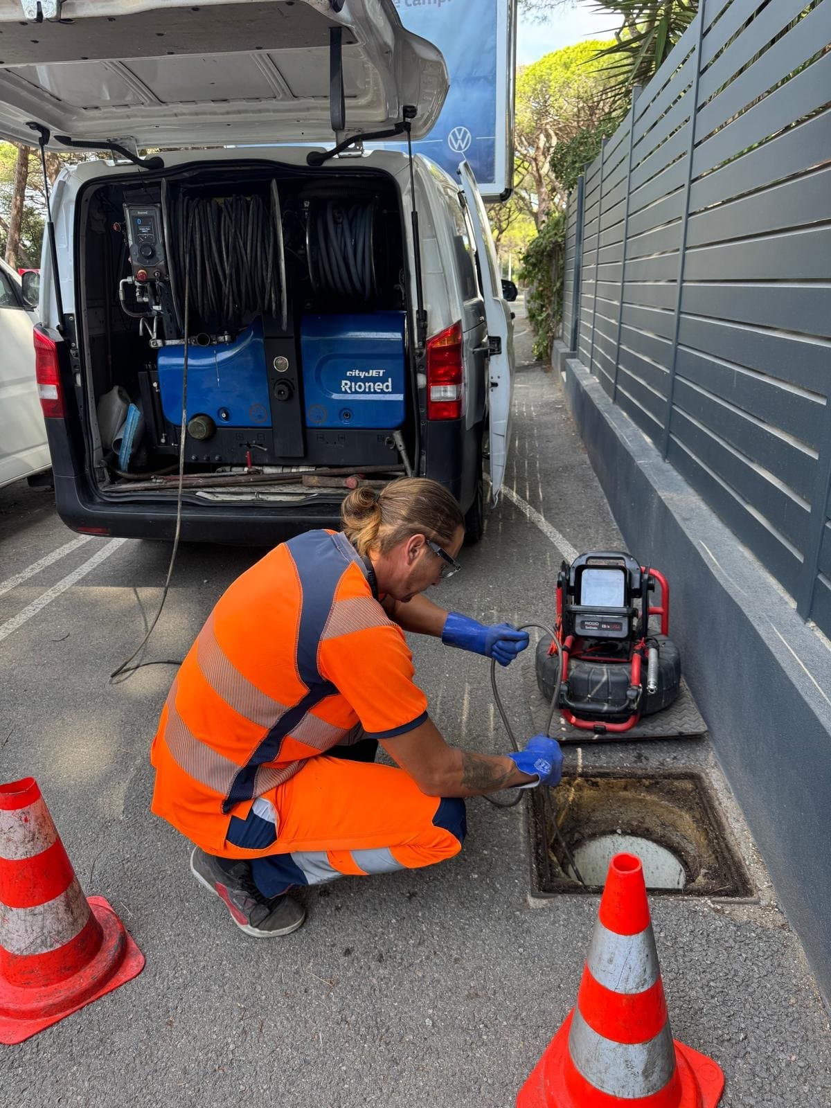Romuald, responsable technique, passe une caméra d'inspection dans un regard devant le camion